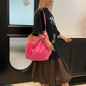 Détail du sac cabas rose vif à texture gaufrée avec lettrage brodé à l'intérieur