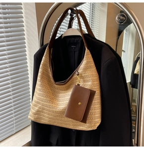 Detail of straw shoulder bag with brown leather strap and mini hanging coin pouch