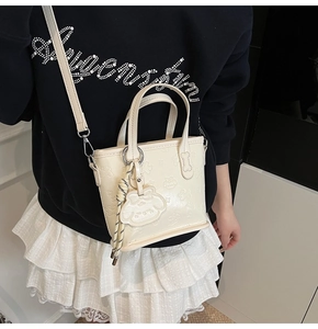 Détail du sac blanc en similicuir avec motif gaufré de dessin animé et crochets en argent