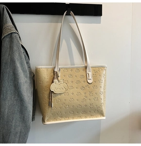 Détail du sac cabas beige avec motifs d'animaux gaufrés et texte Baby Breeze gravé