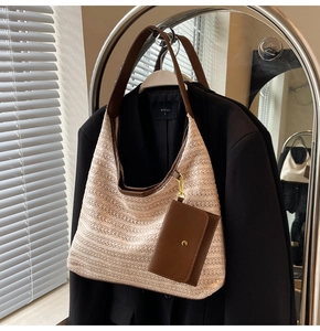 Detail of woven tote bag featuring brown leather trim and magnetic small pouch accessory