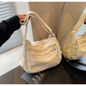 Close-up of beige canvas tote bag with multi-pocket design and adjustable strap detail