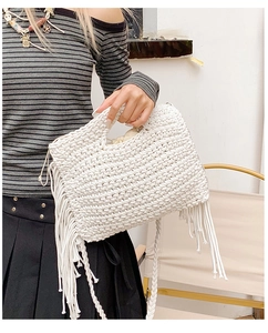 Close-up of white crochet tote bag with long tassels and woven circular handles