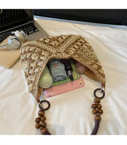 Top-down view of a spacious straw tote bag filled with a tablet, bottle, and umbrella