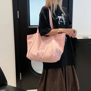 Détail du sac cabas en toile rose montrant la broderie de chien et sa grande capacité pratique