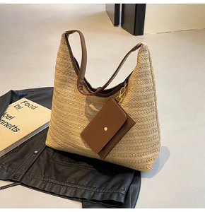 Detail of straw woven tote bag with brown leather strap and matching coin purse charm