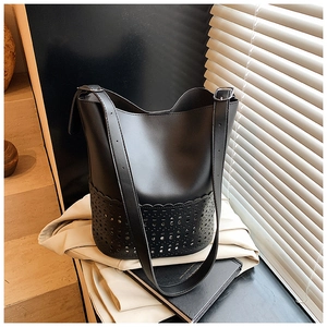 Detail des lasergeschnittenen Blumenmusters auf einer schwarzen Leder-Eimertasche für Damen