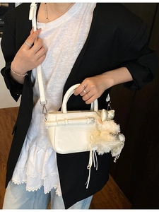 Sac seau blanc minimaliste en cuir verni brillant avec un charme de poupée en peluche