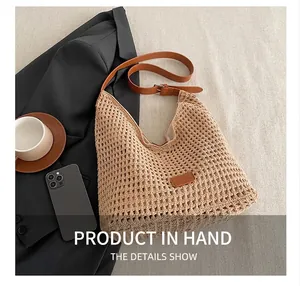 Detail of woven mesh tote with brown leather strap and brand patch on white fabric