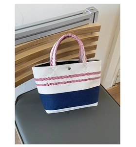 Detailed shot of heavy-duty canvas tote with blue panel and silver metal snap button closure