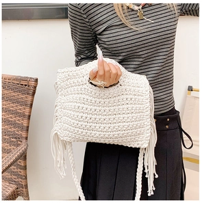 Detail of crochet tote bag with spherical textured weave and long tassels on side