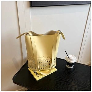 Detailaufnahme der gelben Eimertasche mit lasergeschnittenem Design und Trageriemen
