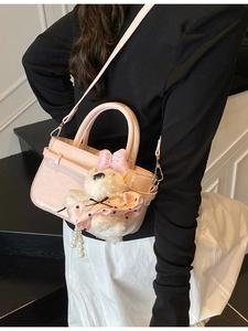 Sac seau rose avec breloque ours en peluche porté en bandoulière sur un mannequin