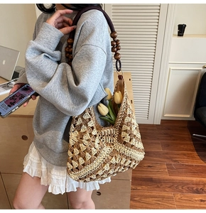 Detail of bohemian woven shoulder bag featuring unique brown wooden beaded straps