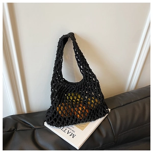 Detail of black hollow out crochet tote bag holding fresh citrus fruit for shopping