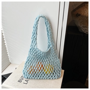Close-up of light blue hollow knit tote bag with fresh oranges and lemons inside