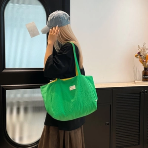 Détail du grand sac cabas texturé vert vif avec une doublure jaune contrastante