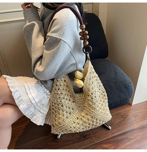 Detail of hand-crocheted hollow texture beach tote with dark brown wooden bead strap
