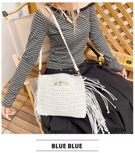 Detailed shot of white cotton crochet shoulder bag with long fringes and woven strap