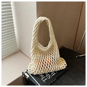 Detailed macro view of the beige hollow out knit pattern and sturdy woven handle texture