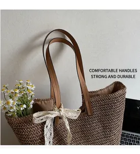 Detail of hand-woven straw tote bag featuring elegant lace bow and sturdy brown handles