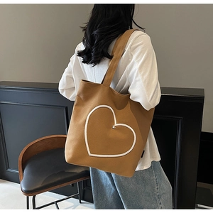 Vue détaillée de la broderie cœur blanc sur le sac cabas en toile couleur camel