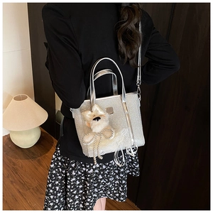 Detail of silver sequin bucket bag with plush puppy charm and adjustable strap