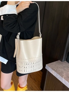 Schicke minimalistische cremefarbene Beuteltasche mit elegantem Laser-Cut-Blumenmuster