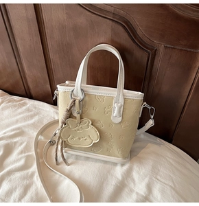Détail du sac cabas en cuir jaune clair avec relief cartoon et charm adorable