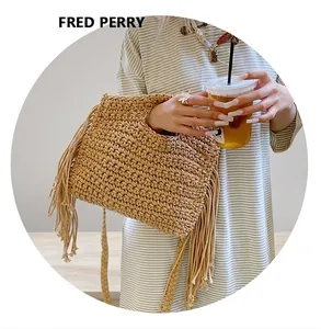 Close-up of beige crochet tote bag featuring long side tassels and woven cotton texture