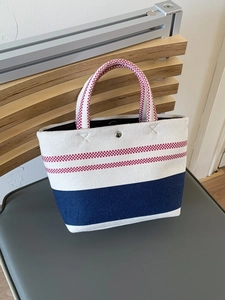 Striped canvas tote bag with red plaid handles and blue bottom stripe contrast design