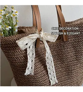 Detail of straw tote bag showing brown woven texture and cream lace bow decoration