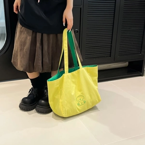 Détail du sac cabas en toile jaune avec broderie de chien verte et doublure vive