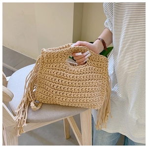 Detail of handmade crochet shoulder bag featuring flowing side fringe and woven texture