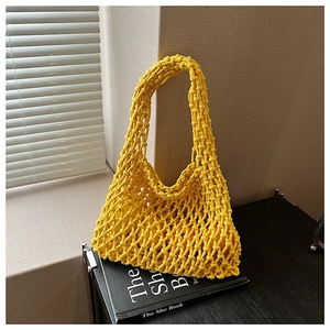 Detailed view of yellow hollow out knit handbag with handmade rope weave texture