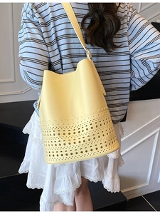 Minimalistische leuchtend gelbe Eimer-Tasche für Damen mit aufwendigen Laser-Cut-Wellenmustern