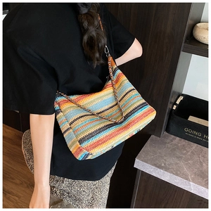 Detailed view of a vibrant rainbow striped woven shoulder bag with a metal chain strap
