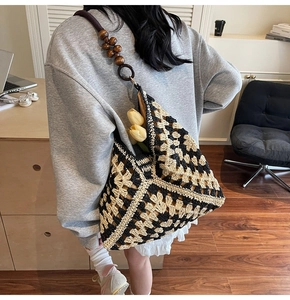 Detail of hand-crocheted woven tote bag featuring geometric floral patterns and wooden beads
