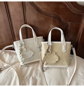 Détail de deux mini sacs cabas en cuir PU crème et blanc avec motif de chien en relief