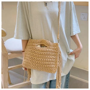 Detail of hand-woven cotton crochet tote bag with elegant side fringe and textured pattern