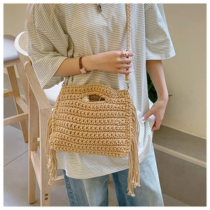 Detailed view of handmade crochet tote bag with fringe tassels and woven shoulder straps