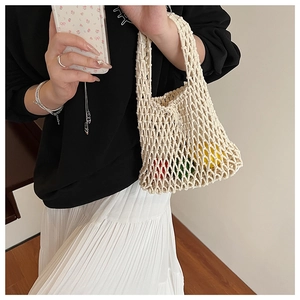 Detail of hand-woven hollow knit tote bag made from beige thick cotton rope material