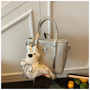 Silver glitter bucket bag featuring a sparkly finish and a cute plush puppy charm