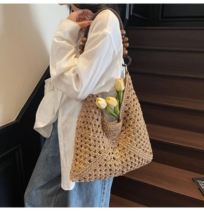 Detail of bohemian woven tote bag featuring hollow crochet texture and wooden bead handles