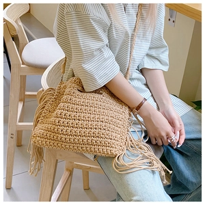 Detail of bohemian cotton crochet tote with long tassels and intricate woven texture