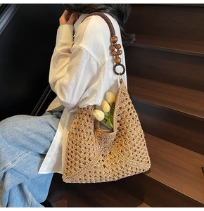 Detail of handwoven straw tote featuring wooden bead straps and a stylish tulip accent