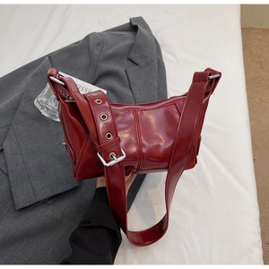 Dettaglio della borsa a mezzaluna in pelle verniciata rosso vivo con hardware in argento
