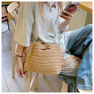 Detailed macro view of the hand-woven cotton thread texture and boho tassel on the tote