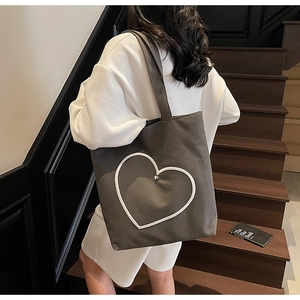 Détail du sac cabas en toile grise avec contour cœur blanc et boucle en métal