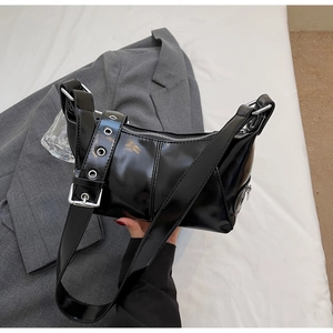 Dettaglio borsa in pelle verniciata nera con fibbia argento e tracolla larga con occhielli